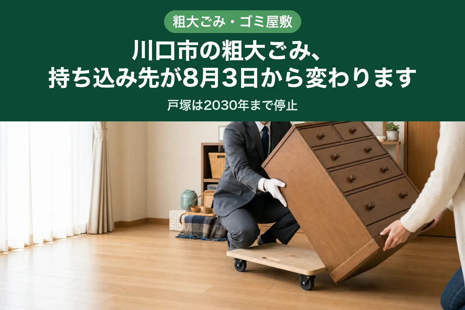 スーツ姿の査定士が木製のタンスを少し傾け、下に家具用の台車を差し込んで運び出す準備をしている様子