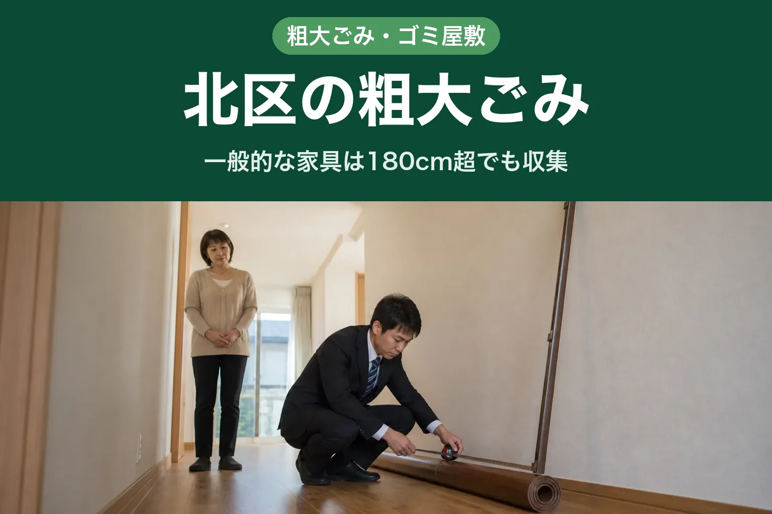 スーツ姿の査定士が、北区のご自宅の廊下でしゃがみ、床に丸めて置かれたウッドカーペットの長さをメジャーで測っている様子。壁には細長いカーテンレールが立てかけられている