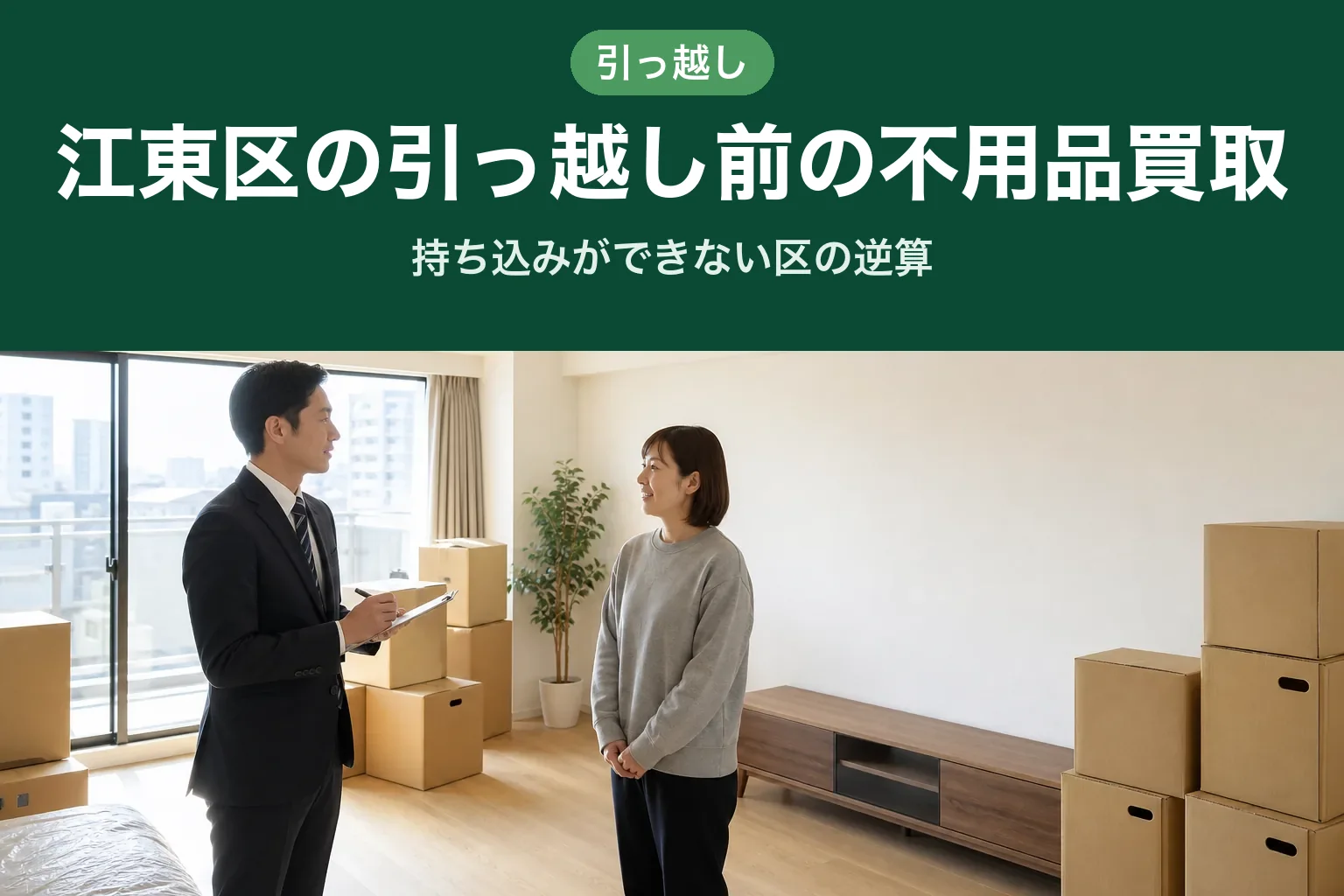 スーツ姿の査定士が、引っ越し前で段ボールが積まれたマンションの一室で、クリップボードに書き込みながらお客様と向かい合って話している様子。奥の壁際にテレビボードが残っている