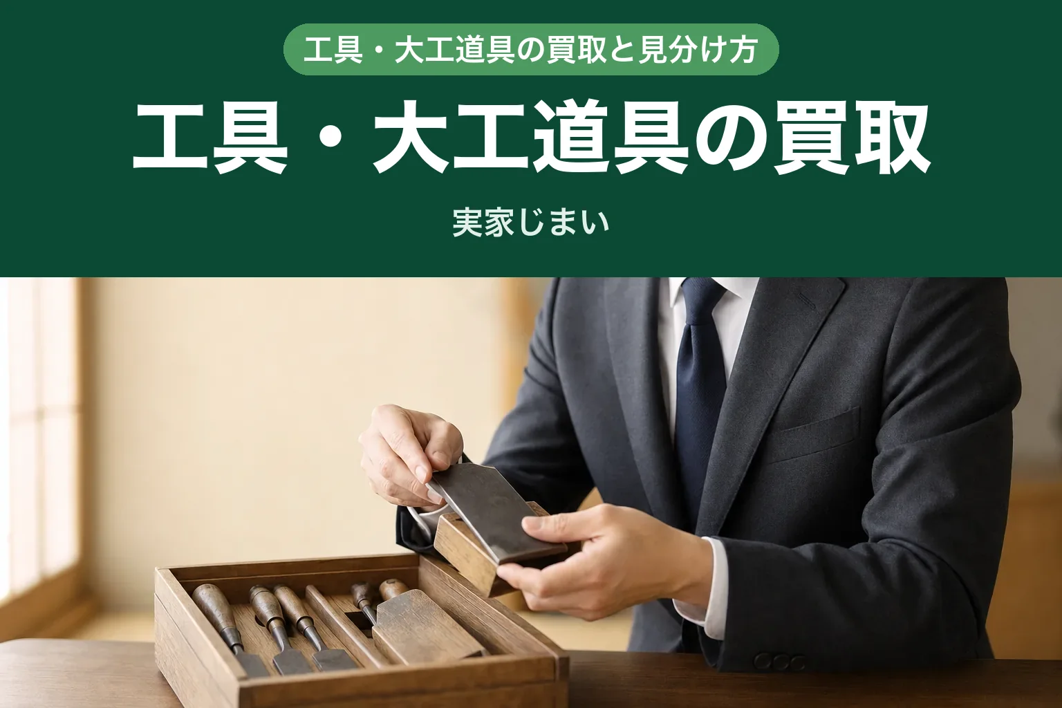 スーツ姿の査定士が、テーブルの上の工具箱とかんな・のみなどの大工道具を丁寧に確認している自宅訪問査定の様子