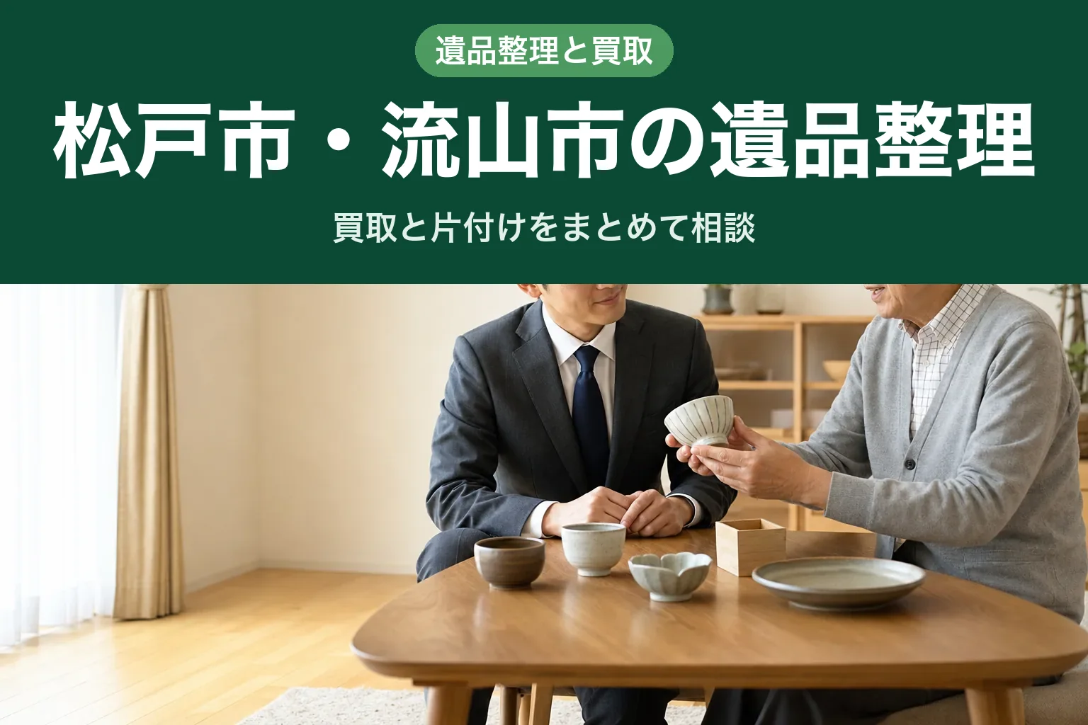 スーツ姿の査定士が、床に置かれた段ボール箱とテーブルの上の食器を確認しながら仕分けている訪問査定の様子