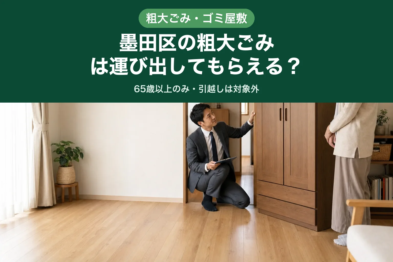 スーツ姿の査定士が大きな洋服ダンスと開いたドアの間に立ち、家具が通るかどうかを見比べている様子